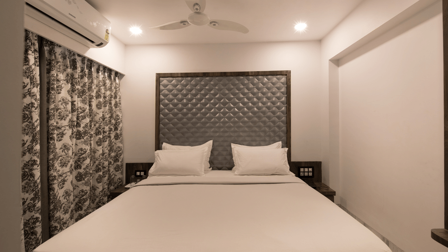 Super deluxe room at Sammukh by Adamo showcasing a well furnished bed and interior.