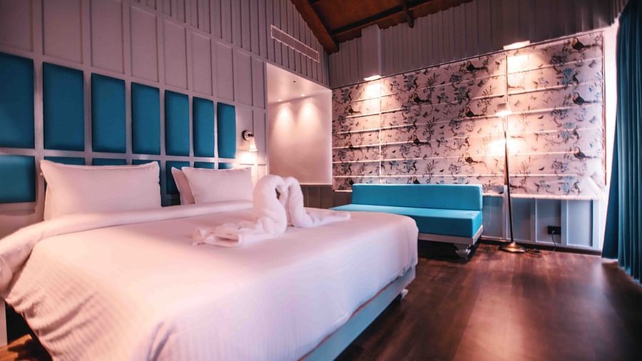 room with a king size bed and blue interiors at Symphony Samudra Beachside Jungle Resort And Spa, Port Blair