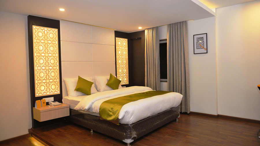 A spacious bedroom with a king bed and side table at The Onyx.