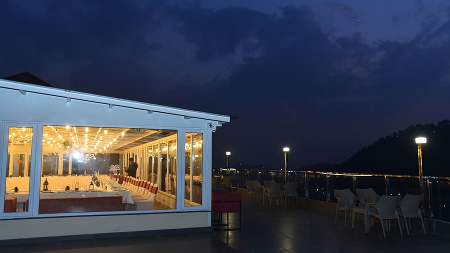 An open architecture building overlooking the lake in the night sky - The Orchid Hotel Shimla
