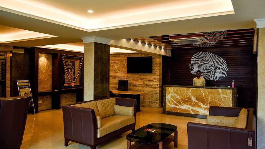 A reception lobby with multiple sofas, table and a TV - Hotel in T Nagar, Chennai 