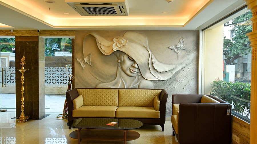 A waiting hall with a beautiful wall carving  and sofas- Hotel in T Nagar, Chennai 