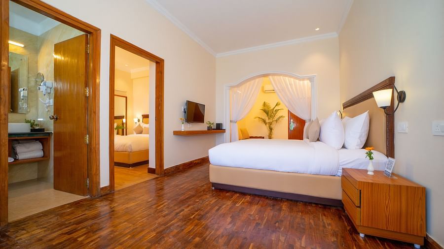 Family Room featuring a plush bed and a nightstand next to it and the room opening up to another room