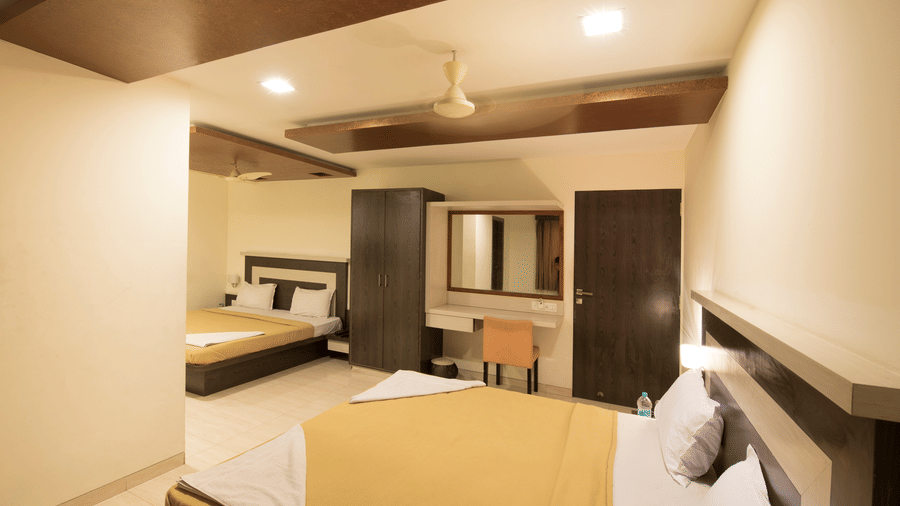 Side view of the family room  featuring a beige bedspread and a dark wood wardrobe.