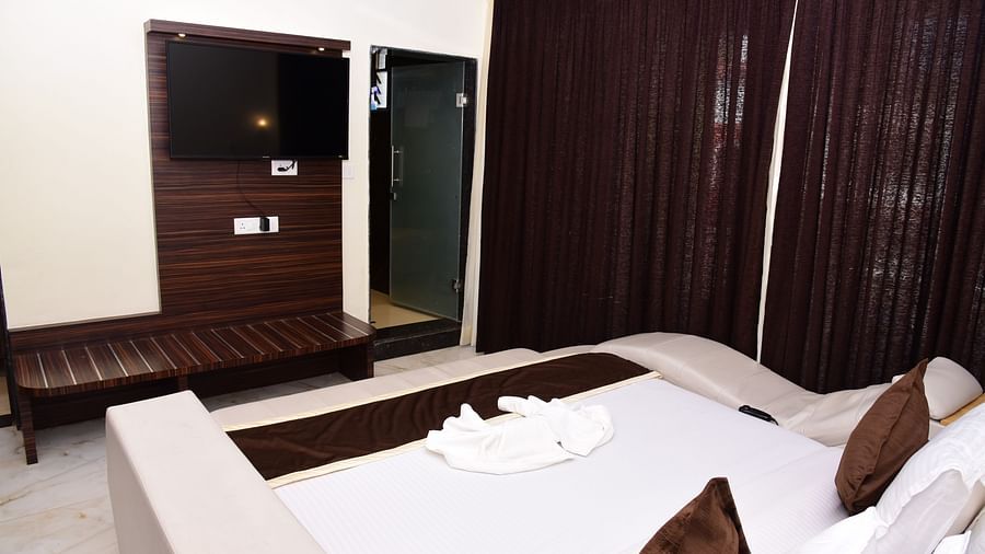 a modern bed with wardrobe, mirror and tv inside one of the rooms at VITS shanti solitaire, North Goa