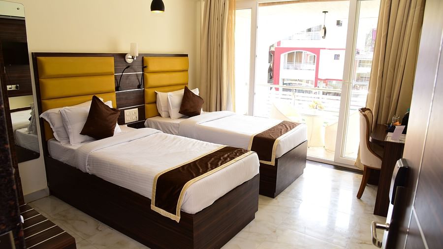 twin beds in front of a study table at one of the rooms at VITS shanti solitaire, North Goa