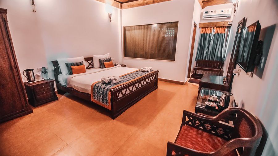Bedroom with wooden furnishings and comforts in Port Blair Resort 