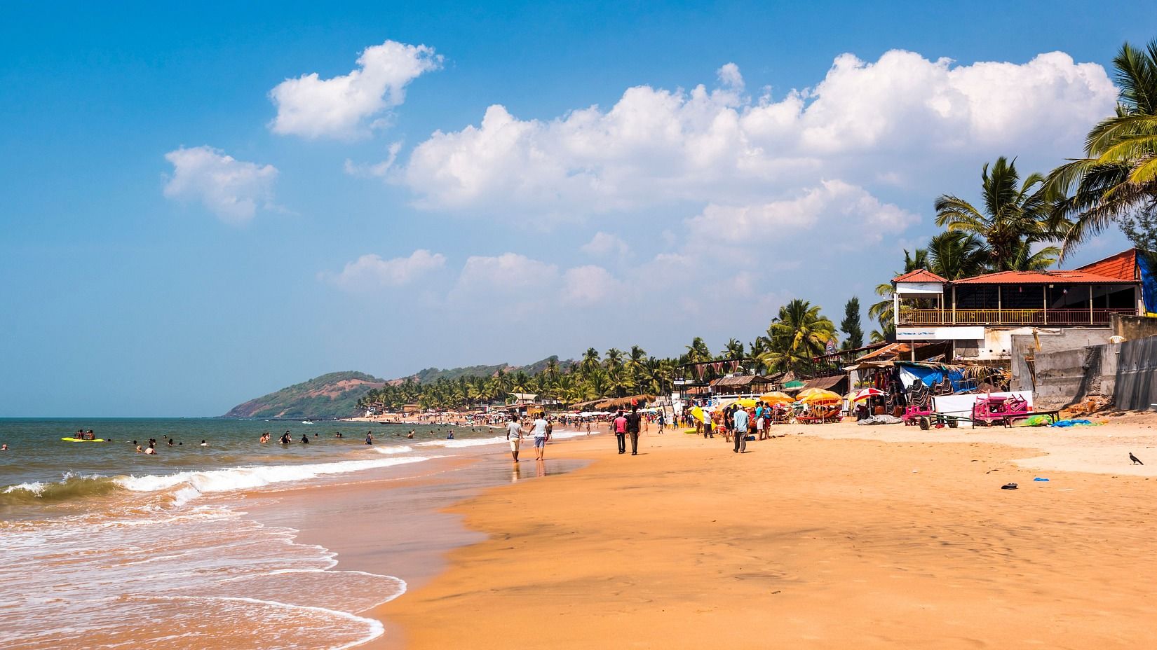 People playing on the beach during summer, near the shoreline.