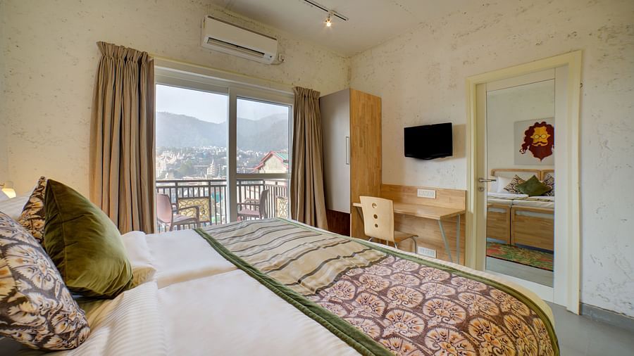 Side view of a room with an air-conditioner and a large bed facing a television - Bedzzz, Rishikesh