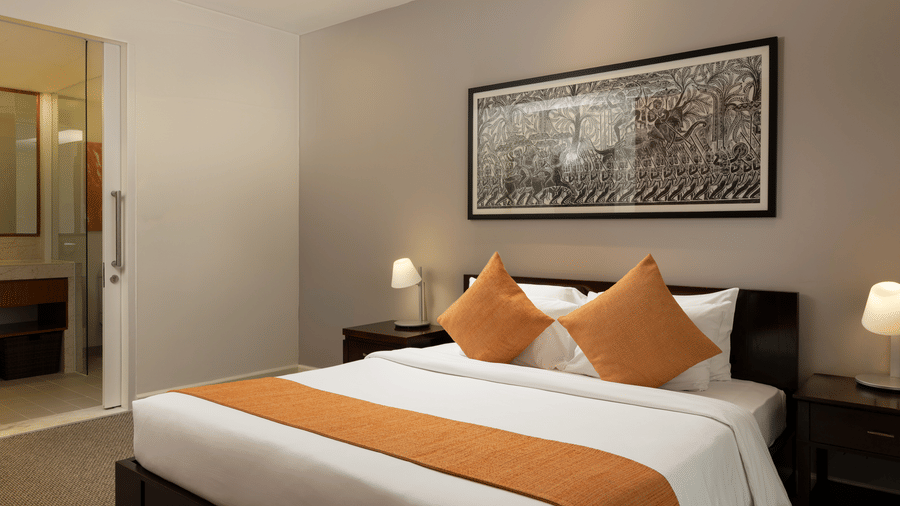 Penthouse bedroom at Central Mansions, Phnom Penh featuring a king bed, bedside lighting, and contemporary furnishings.