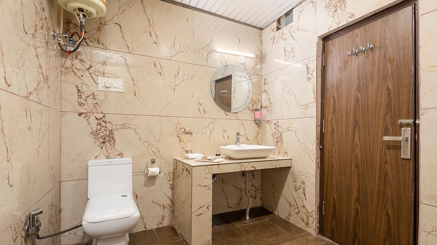 Image of a washroom featuring a basin and a commode | DLS Anupam Resort, Dharamshala