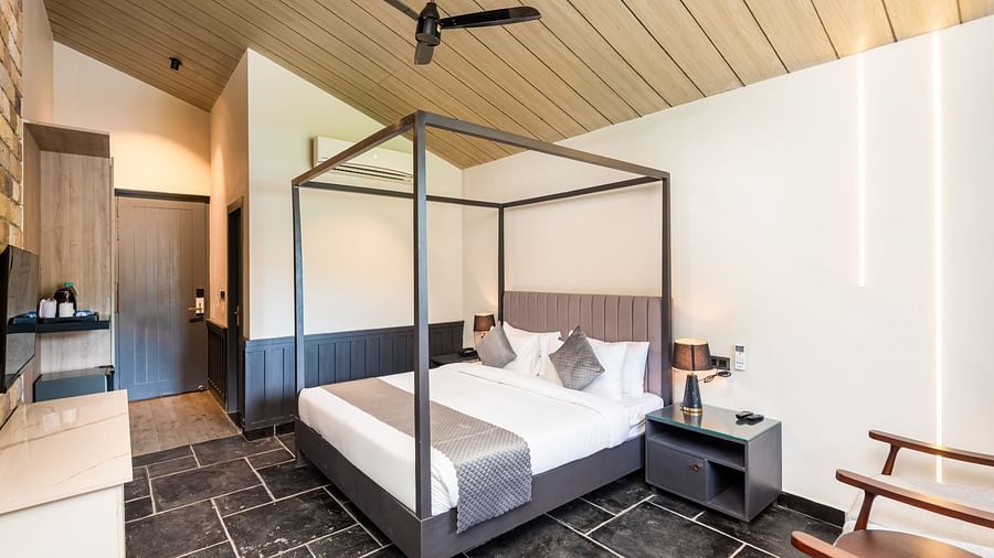 Overview of Luxury Cottage at DLS Divine River Resort and  Spa featuring a  king bed, table, chair and wardrobe.