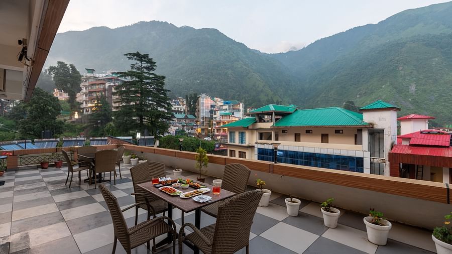 Balcony area at at DLS Spring Valley Resort Dharamshala featuring chairs and tables with a beautiful view 