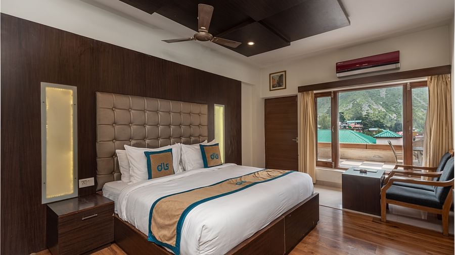 A Premium Room at DLS Spring Valley Resort Dharamshala featuring a king size bed, chair and a balcony