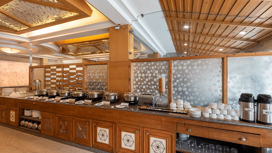 Buffet table at Ruttba restaurant of DLS Spring Valley Resort Dharamshala with food and other cutlery kept