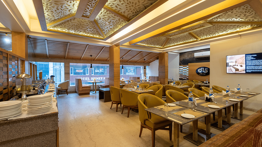 Restaurant at DLS Spring Valley Resort Dharamshala  with seating arrangement and ambient lighting 