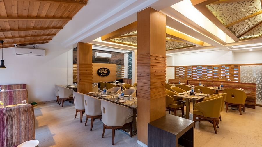 Restaurant at DLS Spring Valley Resort Dharamshala  with seating arrangement and ambient lighting 