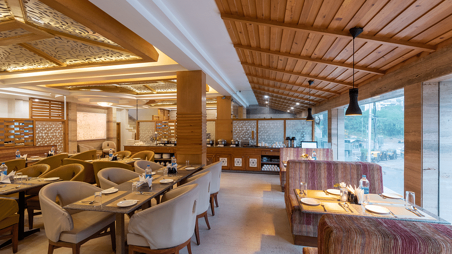 Restaurant at DLS Spring Valley Resort Dharamshala  with seating arrangement and ambient lighting 