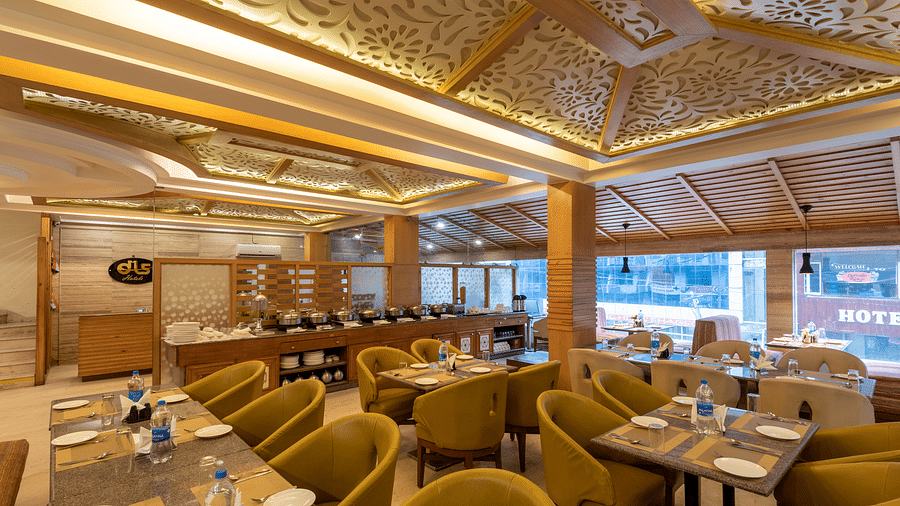 Restaurant at DLS Spring Valley Resort Dharamshala  with seating arrangement and ambient lighting 