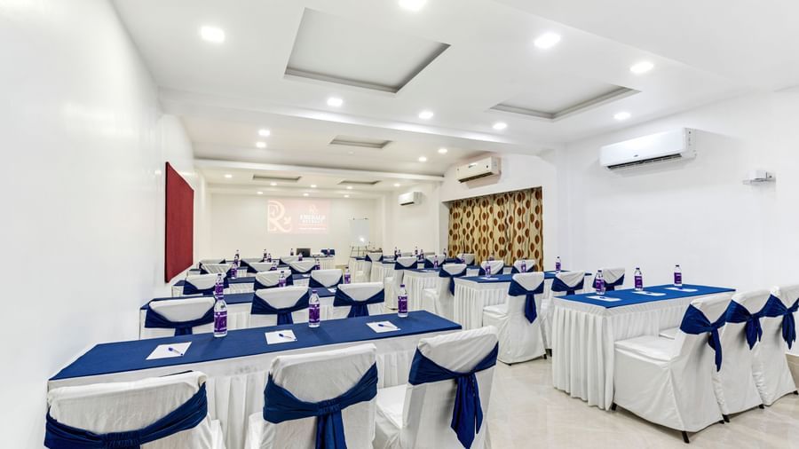 White banquet hall with classroom seating arrangement at Emerald Retreat, Tungarli.