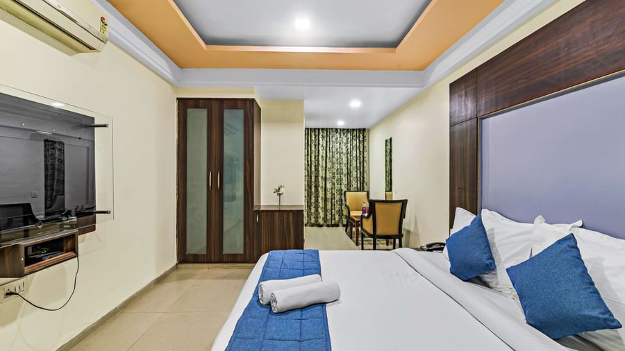 Executive room in Krushnai Resort featuring a double bed with white lnen and blue runner.