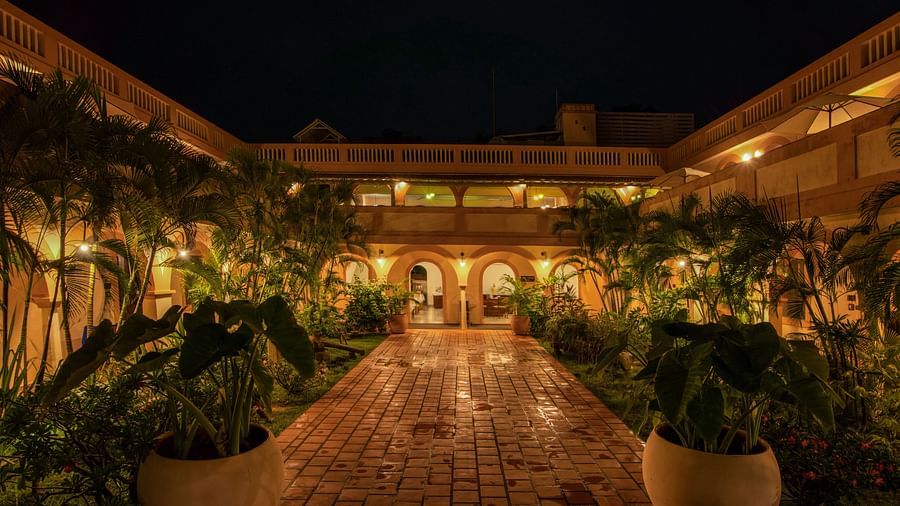 Resort corridor during night time with plants and lights.