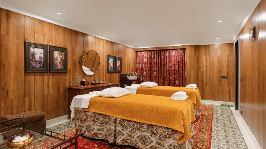 Luxury spa treatment room with massage beds and warm wood panelling at Mayfair Manor, Jungpana.