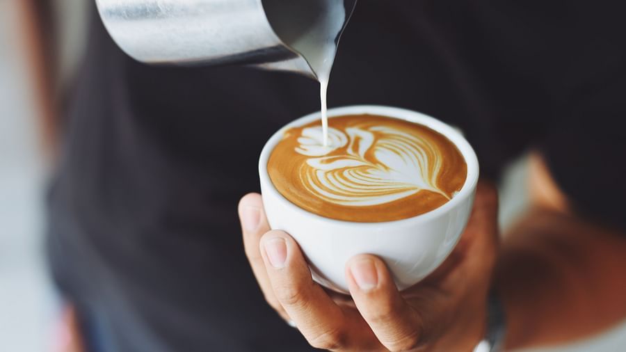 A staff performs coffee art 