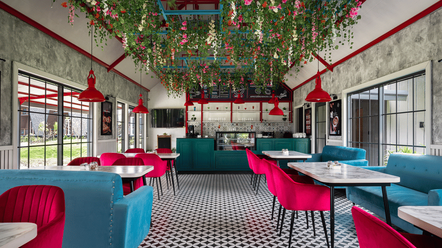 Dining area with sofa seating, and hanging floral decorations at Hotel Sonar Bangla, Taki.