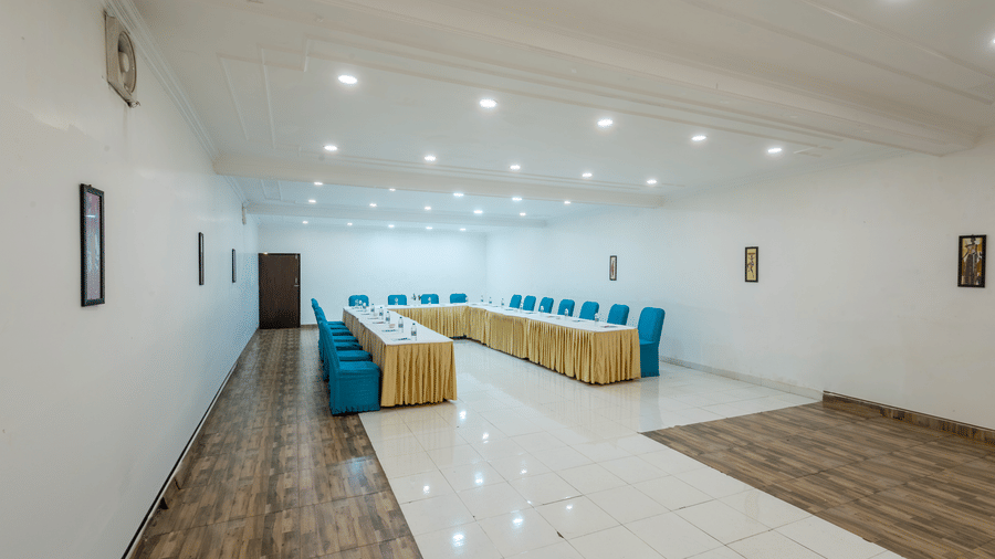 A spacious modern conference hall with bright lighting, arranged seating and polished flooring for formal meetings at The Solitaire Resort.