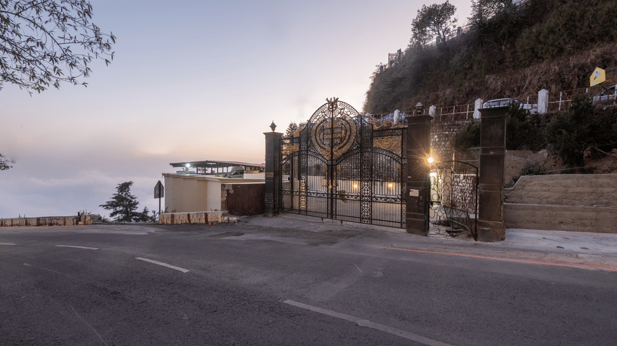 The exterior road view at dusk with warm lighting and stone walls leading towards the inviting entrance at The Solitaire Resort.