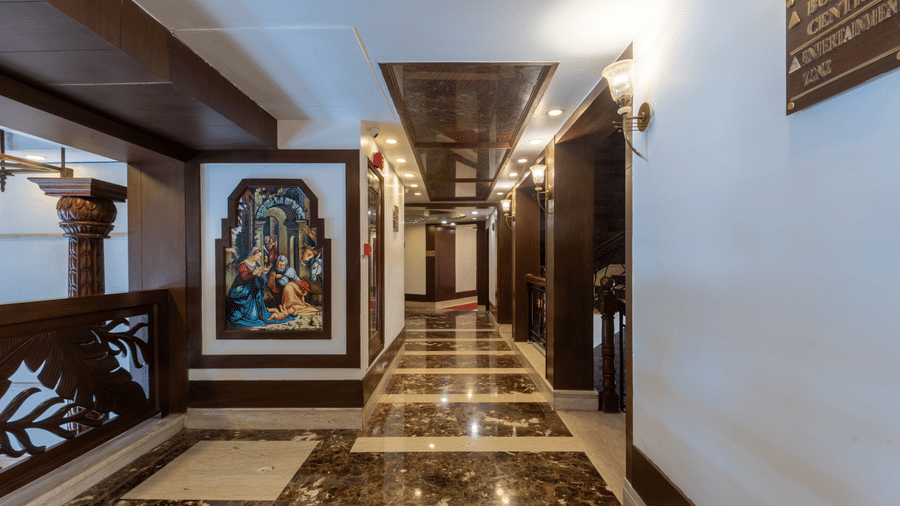 A corridor with polished marble flooring, elegant artwork, and traditional decor creating a charming setting at The Solitaire Resort.