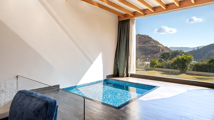 A private plunge pool on a balcony with mountains visible through open wall - Via Lakhela Resort & Spa