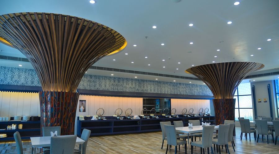 A restaurant with several tables and sofa chairs - Golden Blossom Imperial Resorts, Lucknow