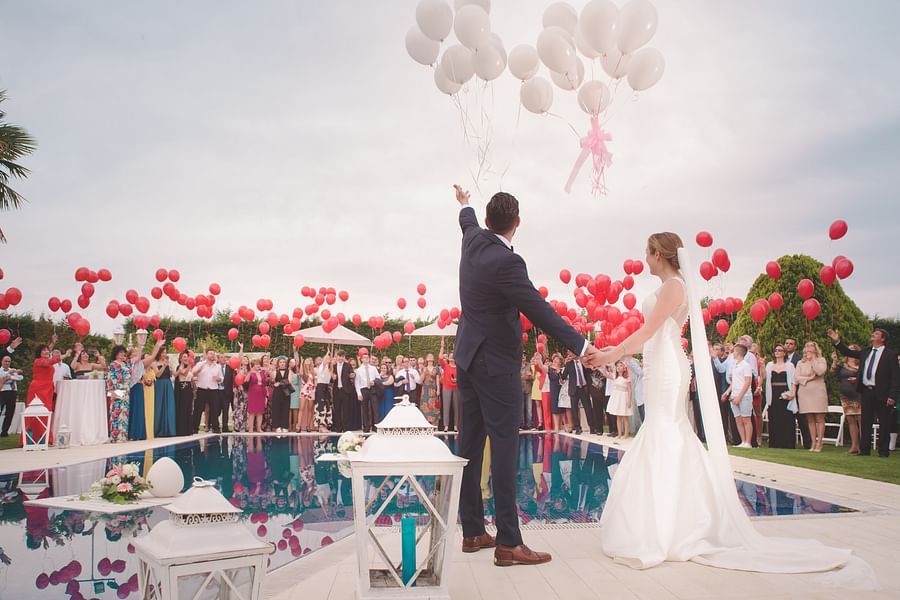 a couple on their wedding day with balloons flying