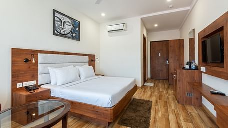 Premium room featuring a tea and coffee maker, air-conditioning, and a Buddha portrait above the bed at DLS The Classio