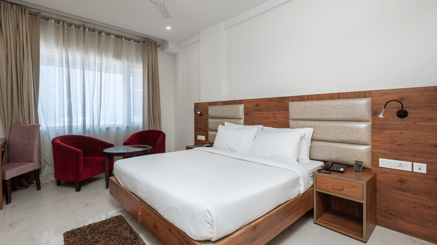  Premium room with a king size bed featuring a stylish headboard, and a window adorned with a soft sheer curtain at DLS The Classio
