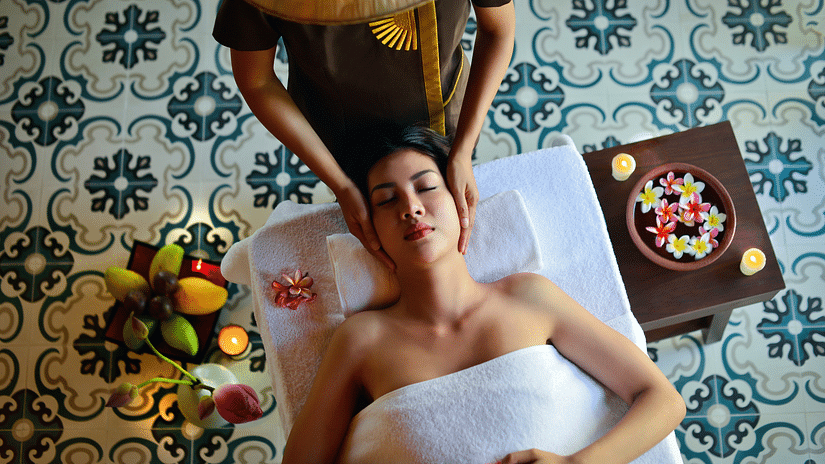 A person on the massage table getting massaged by a therapist in a spa
