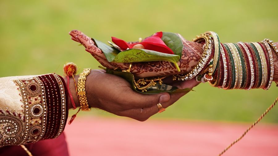 bride and groom holding hands with flowers for wedding ritual