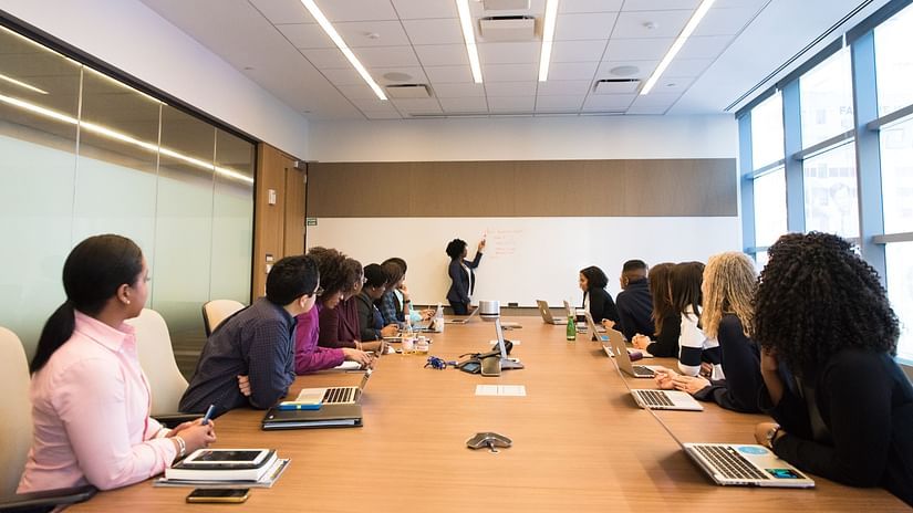 a corporate meeting inside a conference hall with a person in the background explaining something - Corporate Team Outing Chennai