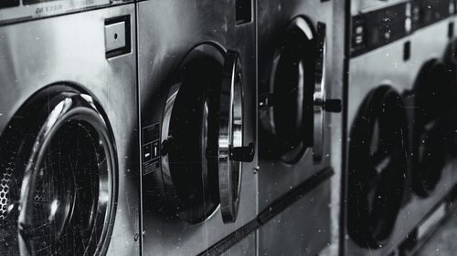 washing machines and dryers stacked next to each other with the image in black and white
