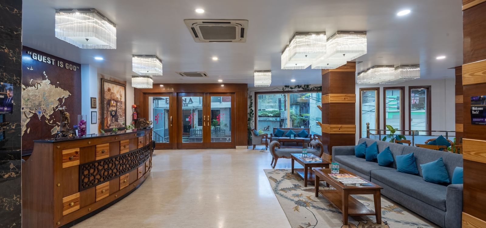 Reception area at DLS Hotels On The Ganges featuring a huge lobby with reception desk on one side, and on the other side there is a seating area with sofa sets. There are also ceiling lights and centralised air conditioners.