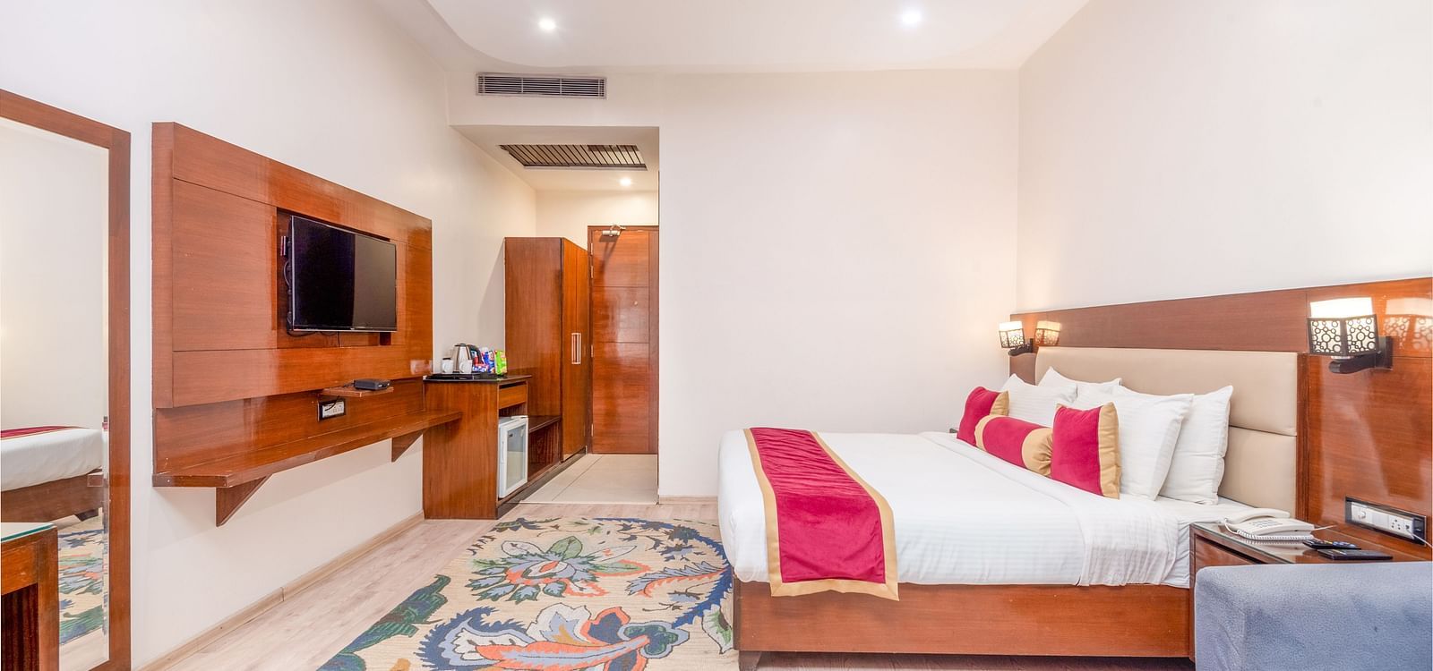 Spacious suite with bed, sofa, and TV at Regenta Inn DLS, Rishikesh.