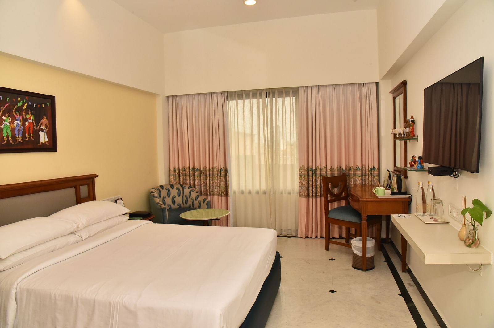 An image of our Deluxe Room featuring a large bed positioned in front of a wall-mounted television - Regency Kanchipuram by GRT Hotels