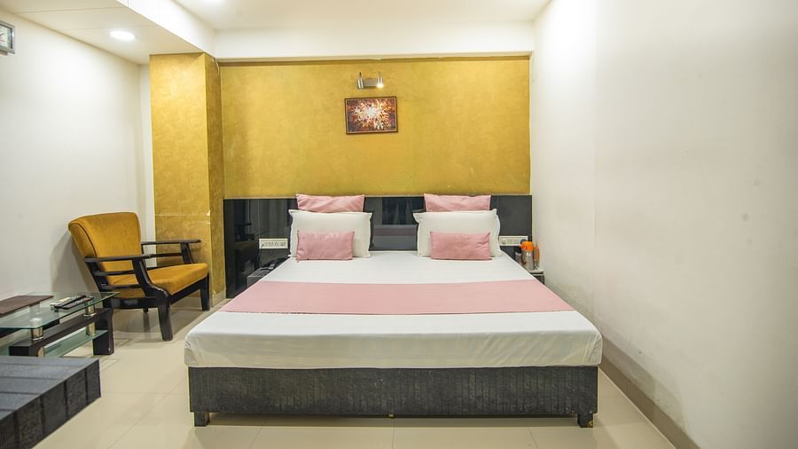 A room featuring a sofa chair, a coffee table, wall painting and side drawers  -  Hotel Morya, Bhopal