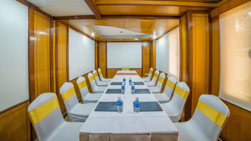A seating arrangement in well-lit Amber Conference Room at Raj Park Hotel Alwarpet Chennai with water bottles placed on the table