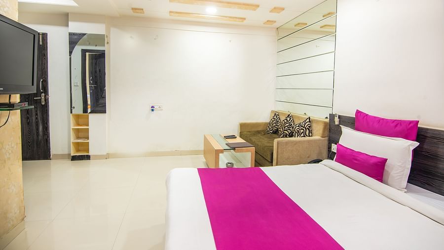 A room featuring a bed, a TV, a coffee table, and a sofa bed - Hotel Morya, Bhopal