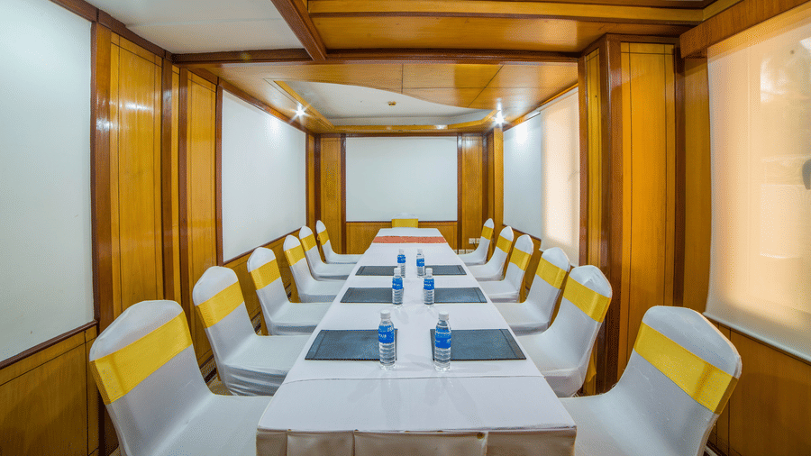 A seating arrangement in a well-lit Amber Conference Room at Raj Park Hotel Alwarpet Chennai with water bottles placed on the table