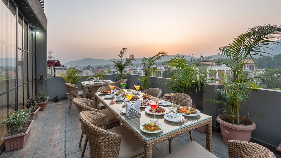 The roof top dining at DLS Hotel Arihant, Haridwar with chairs and tables overlooking the view
