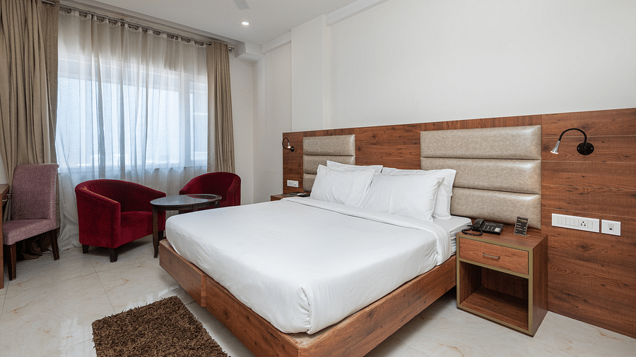  Premium room with a king size bed featuring a stylish headboard, and a window adorned with a soft sheer curtain at DLS The Classio